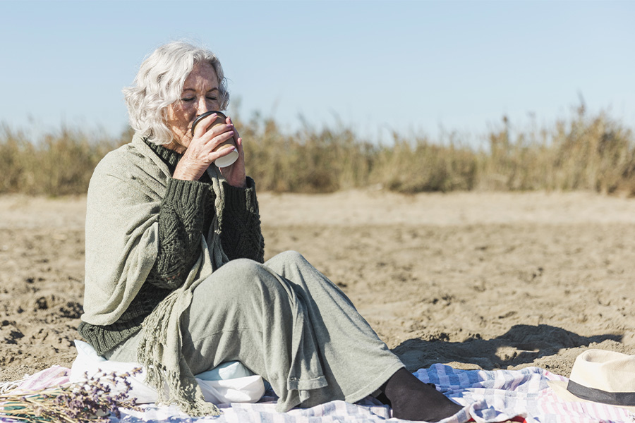 La vejez como etapa vital, representada por una mujer de avanzada edad en la playa